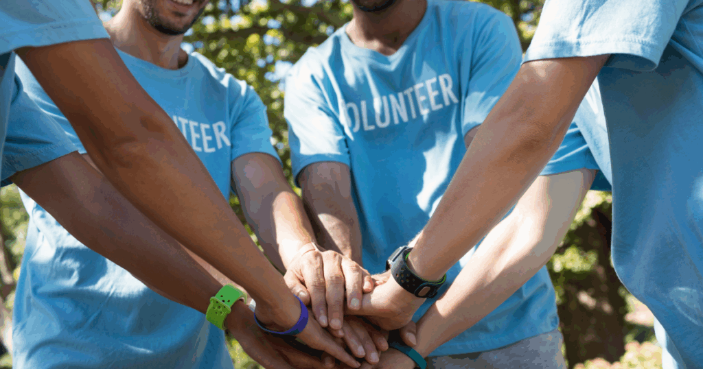 team of volunteers putting their hands into a circle