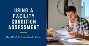 Man sitting at a desk in front of a laptop looking down at papers
