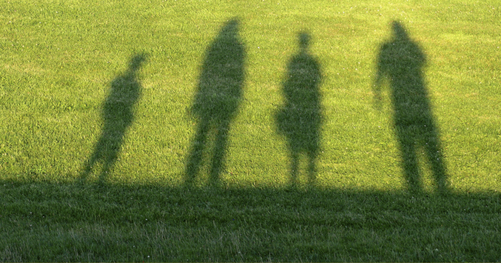silhouettes on the grass of different sized people
