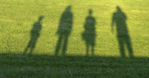 silhouettes on the grass of different sized people